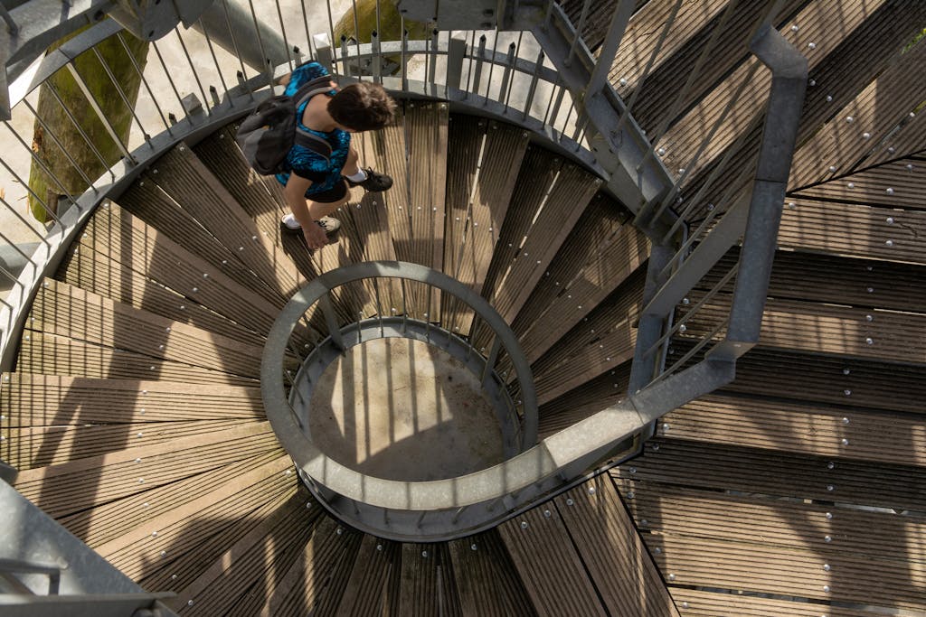 A person walking down a spiral staircase